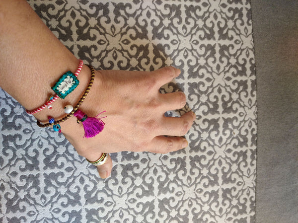 Set of charm bracelets made of silk strings with colorful ornaments in Fuchsia & Turquoise shades.