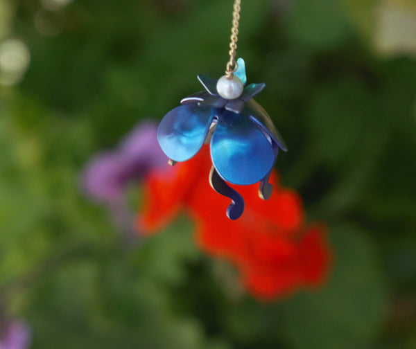Long earrings with golden chain and colorful titanium water lilies in blue, red and green.